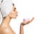 Beautiful woman just after shower with cosmetic patches on skin under eyes holds jar of cream on palm and sends it a kiss