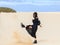 Beautiful woman kicking sand and having fun in desert on Spain