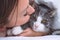 Beautiful woman kissing funny grumpy cat. People and pets love and friendship. Cat and owner together. Cat lover