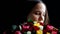 Beautiful woman with a large bouquet of flowers in her arms smelling a fragrant colorful roses on black background