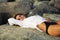 Beautiful woman laying on the beach rocks
