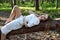 Beautiful woman laying on fallen tree with uncovered legs