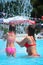 Beautiful woman and little girl bathes in pool