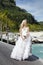 The beautiful woman in a long dress of the bride on the wooden bridge on the tropical island