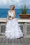 Beautiful woman in a long dress of the bride on the wooden bridge on the tropical island