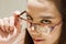 Beautiful woman look through her eyeglasses, concept of finding