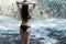 Beautiful woman is looking at waterfall, back view