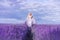 Beautiful woman in a lush long dress runs in a lavender field. A girl in the image of a fairy and a princess of flowers