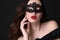 Beautiful woman with luxurious dark hair,with lace mask on face