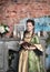 Beautiful woman in medieval dress with book and feather