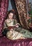 Beautiful woman in medieval dress reading book