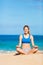 Beautiful woman meditating on the beach