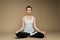 Beautiful woman meditating in yoga lotus position. She looks peaceful, calm and zen. Consideration and praying