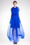 Beautiful woman model posing in long elegant blue silk dress