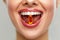 Beautiful Woman Mouth With Pill In Teeth. Girl Taking Vitamins