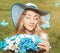 Beautiful woman with multi colored bouquet of daisies on the field background with blue butterflies close up