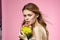 Beautiful woman naked shoulders yellow flower charm cosmetics pink background