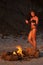 Beautiful woman near the fire on the beach