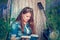 Beautiful woman near the tree and the field with lupine reads a book