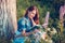 Beautiful woman near the tree and the field with lupine reads a book