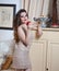 Beautiful woman in nude colored lace dress in vintage scenery holding a red apple in her hand. Long curly hair brunette