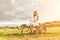 Beautiful woman with an old red bike in a wheat field