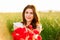 Beautiful woman over Sky and Sunset holding a poppies bouquet and smiling