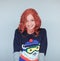 Beautiful woman with perfect red curly hair and make up in a funny winter knit sweater