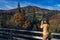 Beautiful woman photographs nature on the mountain in autumn