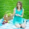 Beautiful woman with picnic basket eating watermelon in summer p
