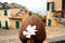 A beautiful woman with a pink flower in her hair looking over the beautiful city of Corniglia in Cinqueterre, Italy