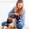 Beautiful woman playing with cute caucasian shepherd puppies