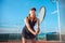 A beautiful woman plays tennis on the court. Sporting black dress suit. The girl smiles, happy. The athlete delivers the