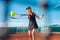A beautiful woman plays tennis on the court. Sporting black dress suit. The girl smiles, happy. The athlete delivers the