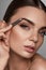 Beautiful Woman Plucking Eyebrows. Beauty Brows Correction