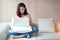 Beautiful woman portrait using computer with white vest and blue jean in living room on relax day