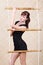 Beautiful woman poses holding bamboo rope ladder.