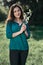 Beautiful woman posing on a glade in the city park, bright sun and shadows on the grass