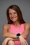 Beautiful woman posing in studio. Portrait of happy young brunette in pink top for yoga or fitness, she stands on gray