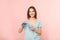 Beautiful woman pouring mouthwash from bottle into glass on color background.