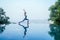 Beautiful woman practice yoga pose on the infinity pool above the mountain peak in the morning in front of beautiful