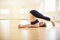 Beautiful woman practices inversion yoga asana Halasana - Plow pose in the yoga studio