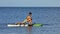 Beautiful woman practices yoga on a stand up paddle board.