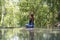 Beautiful woman practicing yoga near turquoise water of cascade waterfall at deep tropical rain forest, island Koh Phangan,