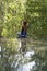 Beautiful woman practicing yoga near turquoise water of cascade waterfall at deep tropical rain forest, island Koh Phangan,