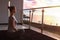 The beautiful woman practicing yoga on a rug and sitting on a balcony with the seaside view.