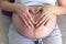 Beautiful woman pregnant hand heart signals