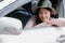 A beautiful woman preparing to travel, looking out of the car door