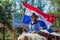 A beautiful woman proudly rides her horse with Paraguayan flag during the annual Paraguayan Independence Day parade.