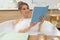 Beautiful woman reading book while enjoying bubble bath at home